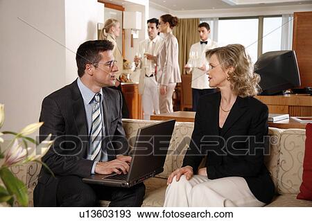 Stock Image - Bussinessman working on a laptop computer during meeting. Fotosearch