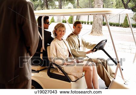 Couple being driven in cart by hotel bellboy View Large Photo Image Stock Image - Couple being driven in cart by hotel bellboy. Fotosearch