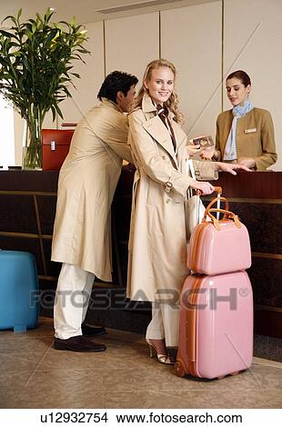 Couple checking in at hotel reception View Large Photo Image Picture - Couple checking in at hotel reception. Fotosearch