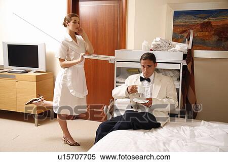 Stock Photography - Hotel maid and waiter taking a break. Fotosearch