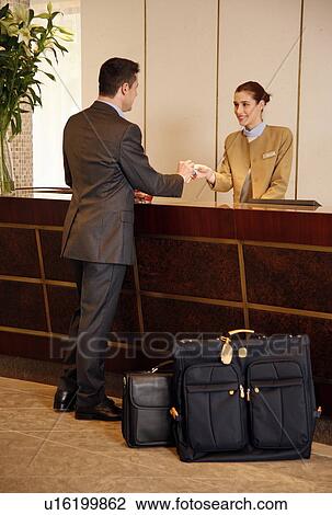 Man checking in at the hotel reception desk View Large Photo Image Stock Image - Man checking in at the hotel reception desk. Fotosearch