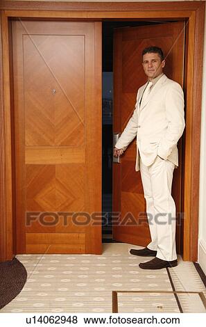 Stock Photo - Man putting card key into hotel room door. Fotosearch