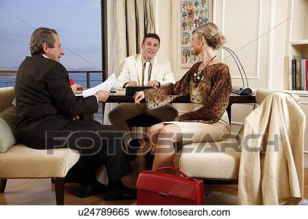Stock Photography - Three business people working in a hotel room. Fotosearch