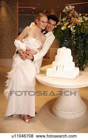 Stock Photo - Bride and groom with cake. Fotosearch