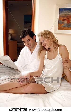 Stock Photography - Couple on bed in hotel room. Fotosearch