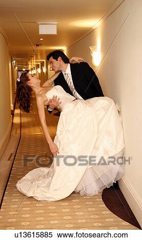 Stock Photography - Groom carrying bride into hotel room. Fotosearch