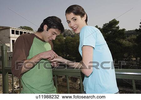 Stock Image - Man reading woman's palm at archaeological site. Fotosearch