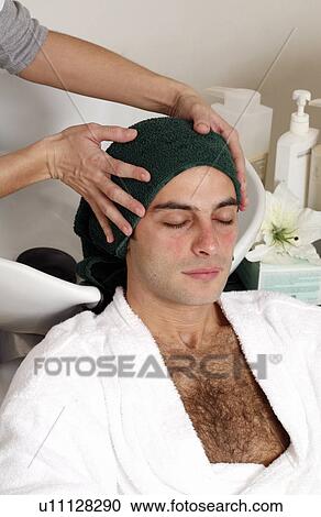 Young man having his hair washed at a salon View Large Photo Image Stock Image - Young man having his hair washed at a salon. Fotosearch
