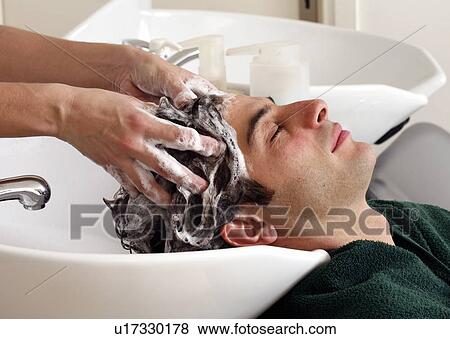Stock Photo - Young man having his hair washed at a salon. Fotosearch