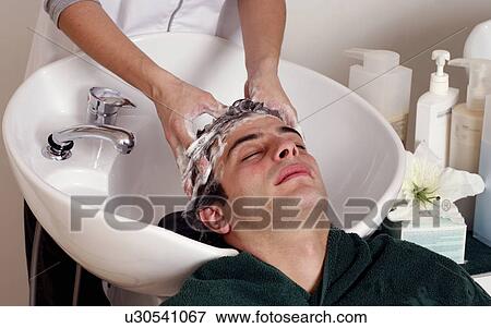Young man having his hair washed at a salon View Large Photo Image Stock Photo - Young man having his hair washed at a salon. Fotosearch