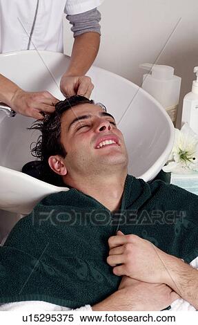 Young man having his hair washed at a salon View Large Photo Image Stock Photography - Young man having his hair washed at a salon. Fotosearch