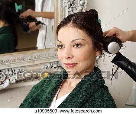 Stock Photo - Young woman having her hair curled. Fotosearch