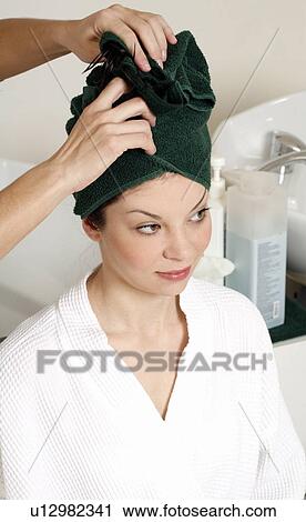 Stock Image - Young woman having her hair washed at a salon. Fotosearch