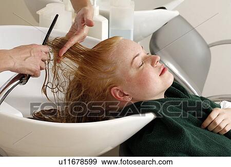 Stock Photo - Young woman having her hair washed at a salon. Fotosearch