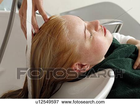Stock Photo - Young woman having her hair washed at a salon. Fotosearch
