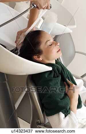 Stock Photo - Young woman having her hair washed at a salon. Fotosearch