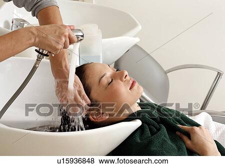 Stock Photo - Young woman having her hair washed at a salon. Fotosearch