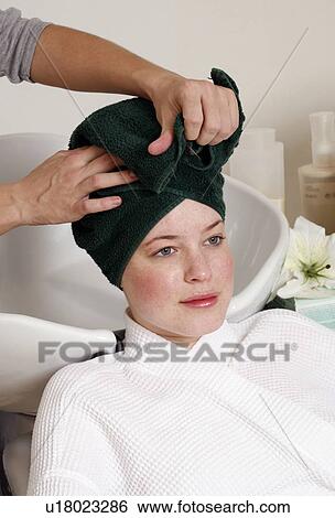 Stock Photograph - Young woman having her hair washed at a salon. Fotosearch
