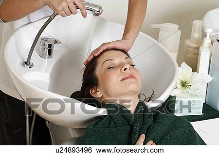 Young woman having her hair washed at a salon View Large Photo Image Stock Photograph - Young woman having her hair washed at a salon. Fotosearch