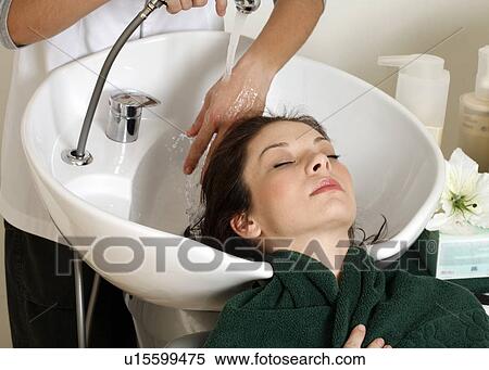 Stock Photography - Young woman having her hair washed at a salon. Fotosearch