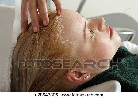 Stock Photography - Young woman having her hair washed at a salon. Fotosearch