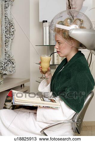 Young woman sitting under hairdryer View Large Photo Image Stock Image - Young woman sitting under hairdryer. Fotosearch