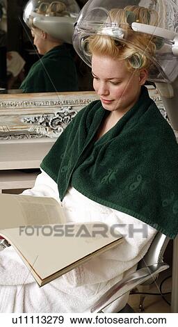 Young woman sitting under hairdryer View Large Photo Image Stock Photo - Young woman sitting under hairdryer. Fotosearch