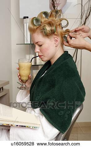 Stock Photo - Young woman sitting under hairdryer. Fotosearch