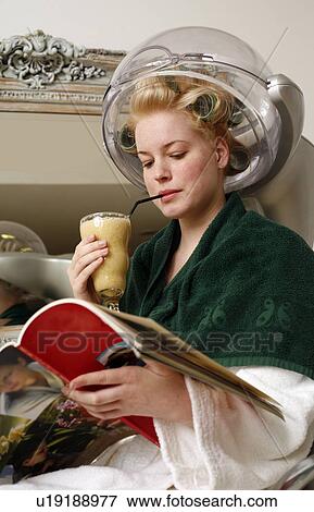 Young woman sitting under hairdryer View Large Photo Image Stock Photo - Young woman sitting under hairdryer. Fotosearch