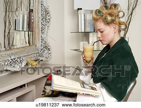 Stock Photo - Young woman sitting under hairdryer. Fotosearch