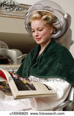 Young woman sitting under hairdryer View Large Photo Image Stock Photography - Young woman sitting under hairdryer. Fotosearch