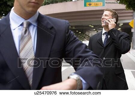 Stock Photograph - A Pair of Businessman in front of a Tunnel, Front View, Waist Up, Close Up, Differential Focus. Fotosearch
