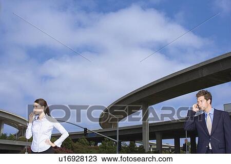 A Pair of Office Workers Talking on a Cellular Phone, Waist Up View Large Photo Image Stock Image - A Pair of Office Workers Talking on a Cellular Phone, Waist Up. Fotosearch