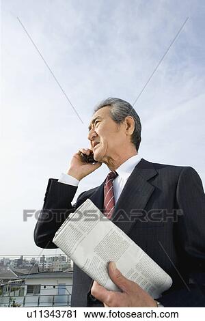 A Senior Adult Man Talking on a Mobile Phone Under the Sky, Low Angle View, Side View View Large Photo Image Stock Image - A Senior Adult Man Talking on a Mobile Phone Under the Sky, Low Angle View, Side View. Fotosearch