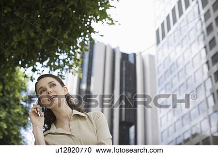 A Young Adult Businesswoman Talking on a Cellular Phone, Low Angle View, Front View, Head and Shoulders, Differential Focus View Large Photo Image Stock Image - A Young Adult Businesswoman Talking on a Cellular Phone, Low Angle View, Front View, Head and Shoulders, Differential Focus. Fotosearch
