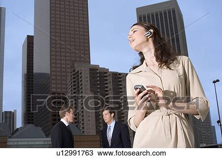 A Young Adult Businesswoman Talking on a Cellular Phone Headset, Low Angle View, Front View, Waist Up View Large Photo Image Stock Image - A Young Adult Businesswoman Talking on a Cellular Phone Headset, Low Angle View, Front View, Waist Up. Fotosearch