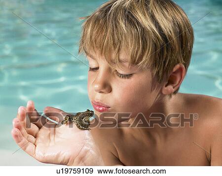 Stock Photo - Boy holding a frog in his hand.. Fotosearch