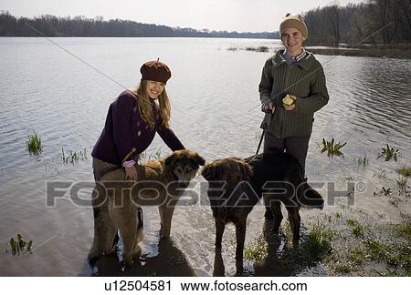 Brother (12-14) and sister (11-13) standing in river with two dogs, smiling View Large Photo Image Stock Image - Brother (12-14) and sister (11-13) standing in river with two dogs, smiling. Fotosearch