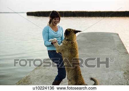 Girl playing with dog by lake. View Large Photo Image Stock Photograph - Girl playing with dog by lake.. Fotosearch
