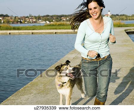 Woman running with dog by a lake. View Large Photo Image Stock Photo - Woman running with dog by a lake.. Fotosearch