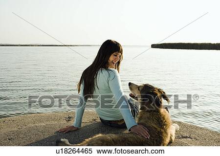Woman sitting by lake with dog. View Large Photo Image Stock Photography - Woman sitting by lake with dog.. Fotosearch
