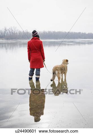 Young woman standing in river with dog on lead, rear view View Large Photo Image Stock Image - Young woman standing in river with dog on lead, rear view. Fotosearch