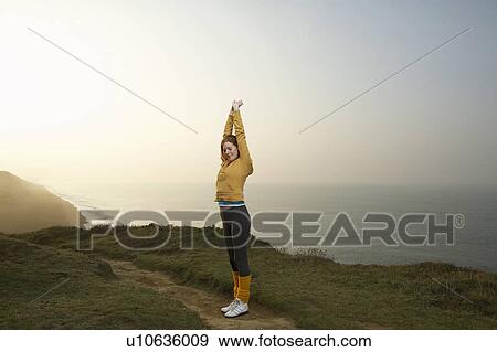 A woman stretching next to a cliff path. View Large Photo Image Stock Photo - A woman stretching next to a cliff path.. Fotosearch