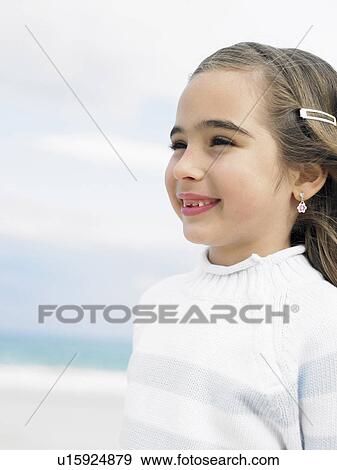 Girl (6-8) on beach smiling, close-up View Large Photo Image Stock Photo - Girl (6-8) on beach smiling, close-up. Fotosearch