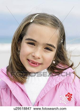Girl (6-8) on beach smiling, portrait, close-up View Large Photo Image Stock Photo - Girl (6-8) on beach smiling, portrait, close-up. Fotosearch
