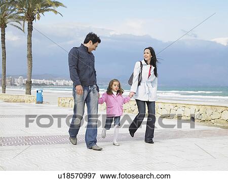 Mother and father walking along palm lined pavement by the sea with young daughter (6-8). Alicante, Spain. View Large Photo Image Stock Photo - Mother and father walking along palm lined pavement by the sea with young daughter (6-8). Alicante, Spain.. Fotosearch