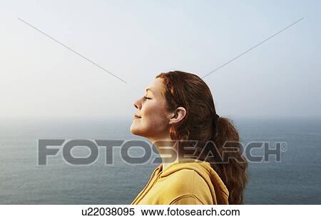 Stock Photography - Profile of a young Woman by the sea.. Fotosearch