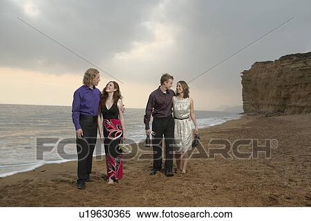 Two couples walking the beach at sunset. View Large Photo Image Stock Photography - Two couples walking the beach at sunset.. Fotosearch