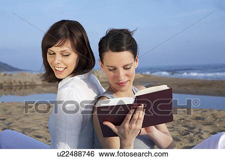 two women sitting together on beach reading View Large Photo Image Stock Photograph - two women sitting together on beach reading. Fotosearch