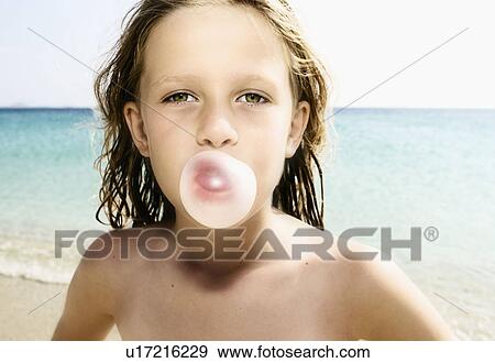 Stock Photo - Young girl at the beach blowing a bubble with her gum.. Fotosearch